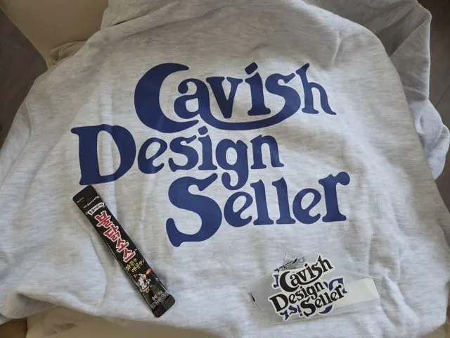 Grey Cavish Design Seller hoodie beside a Korean snack stick